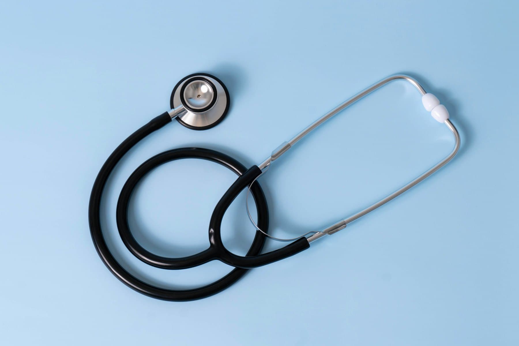 A stethoscope on a light blue background