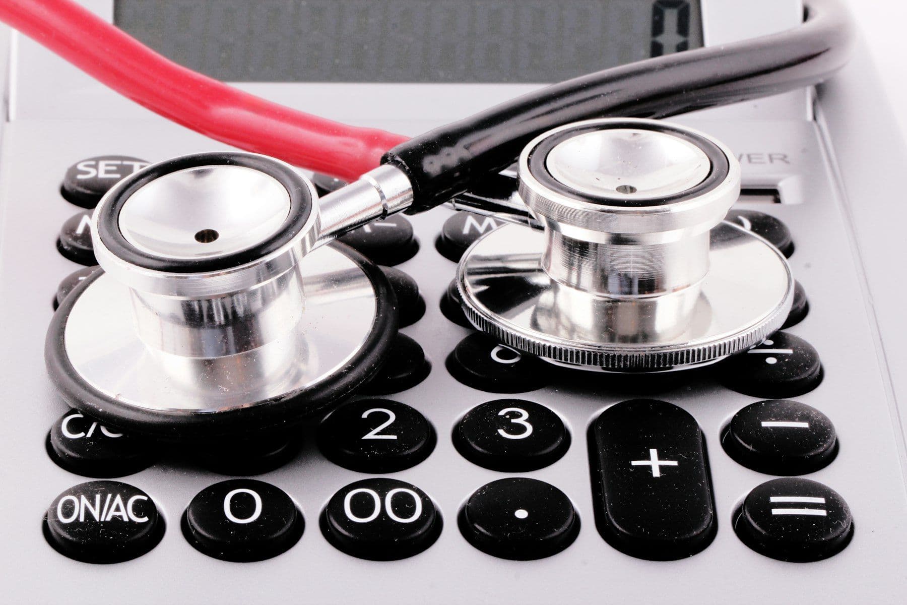 A stethoscope resting on a calculator