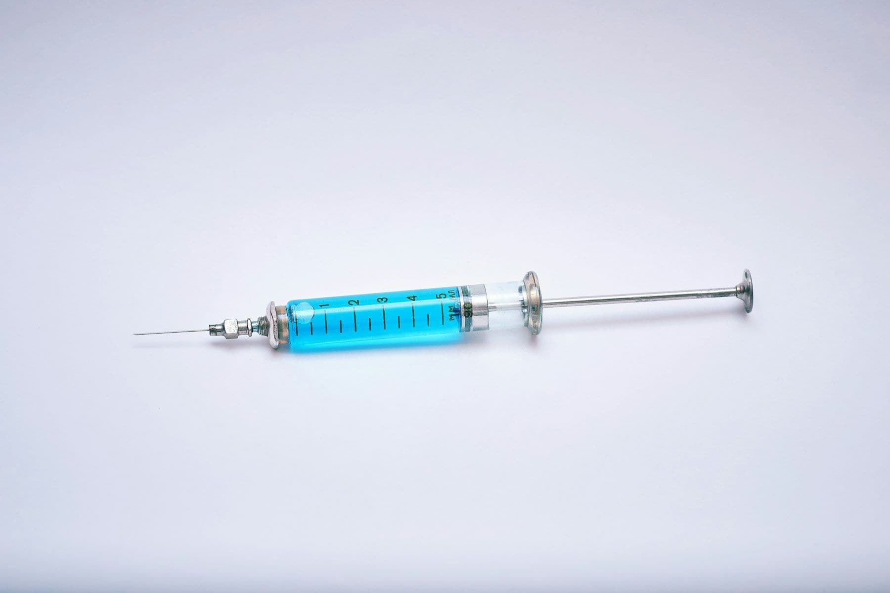 A syringe with blue liquid on a white background